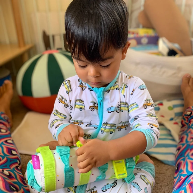 Little boy buckling The Buckle Barrel from The Companion Play Kit