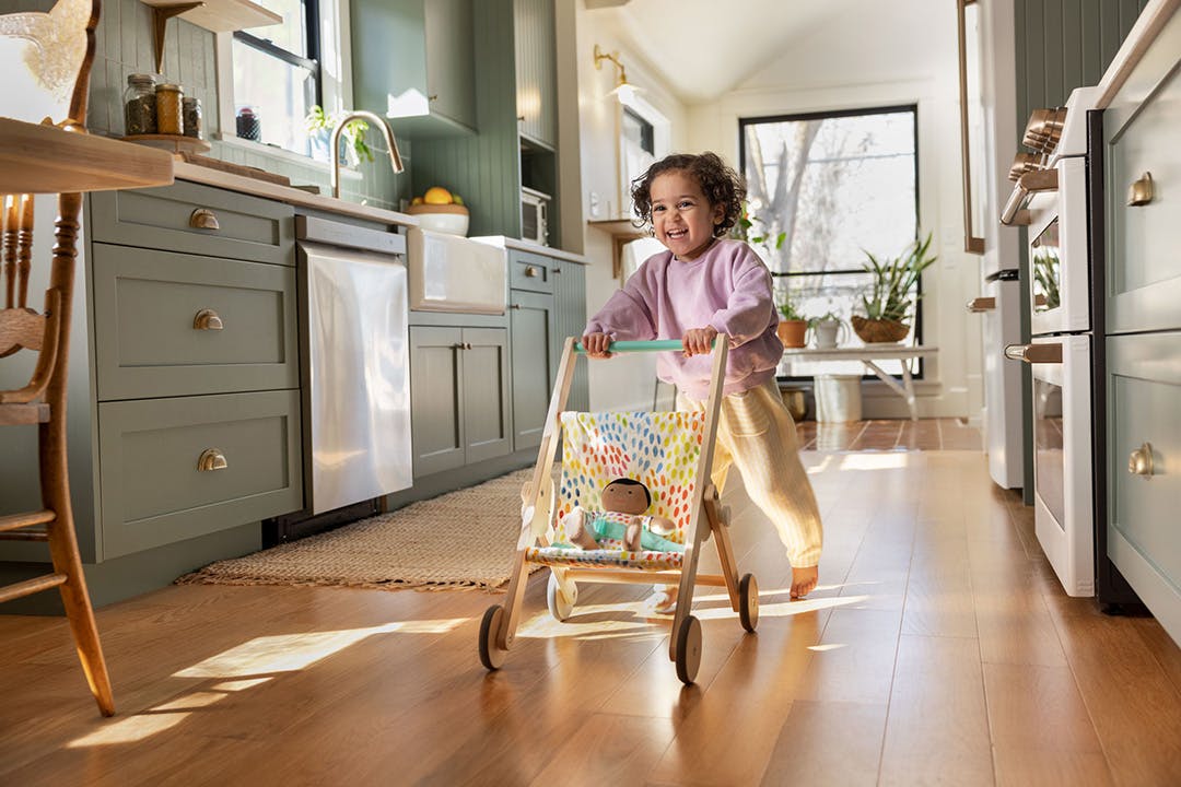 Child pushing The Buddy Stroller by Lovevery