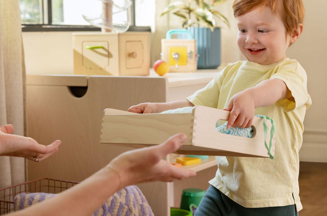 Child carrying the Wooden Trays by Lovevery